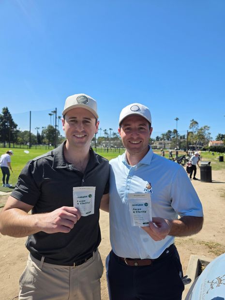 Two golfers holding birdiegum packs